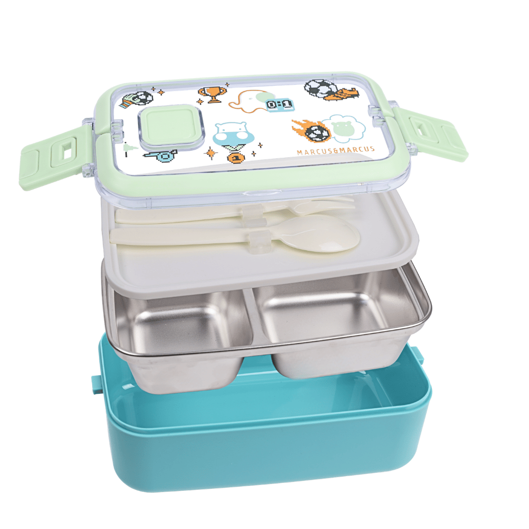 A 2-compartment stainless steel lunch box with a light blue base and a light green lid decorated with cartoon graphics. The box is shown open with a white plastic spoon inside, set against a plain white background.